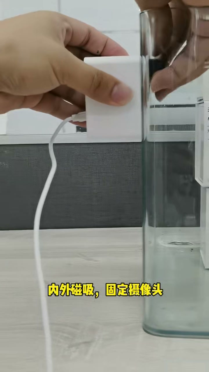 摄像头位于鱼缸外侧,操作者从内侧放置磁吸块辅助固定。
